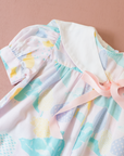 Pastel colored overalls with tree print and doll on a string | 18-24 months