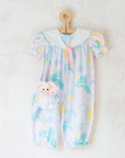 Pastel colored overalls with tree print and doll on a string | 18-24 months