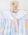Pastel colored overalls with tree print and doll on a string | 18-24 months