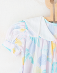 Pastel colored overalls with tree print and doll on a string | 18-24 months