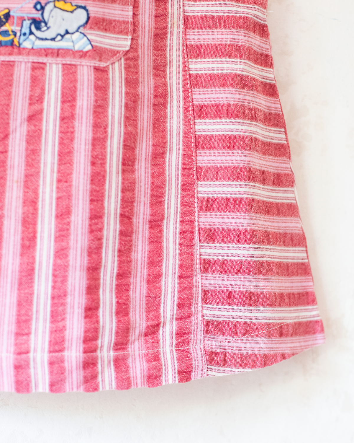 Red striped dress with embroidery of the king playing in the sand | 9-12 months