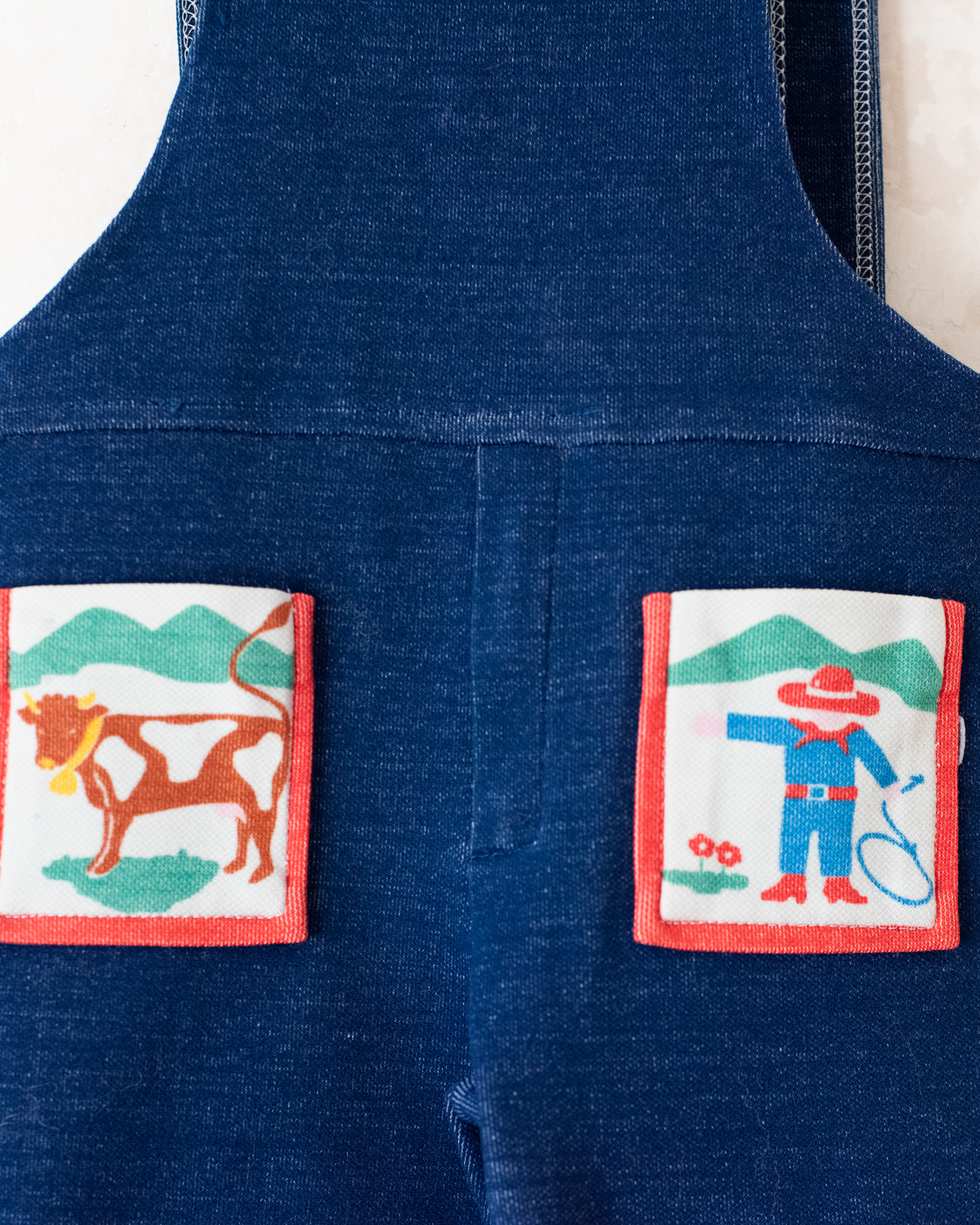 Blue overalls from the seventies with a cowboy and a cow | 18-24 months