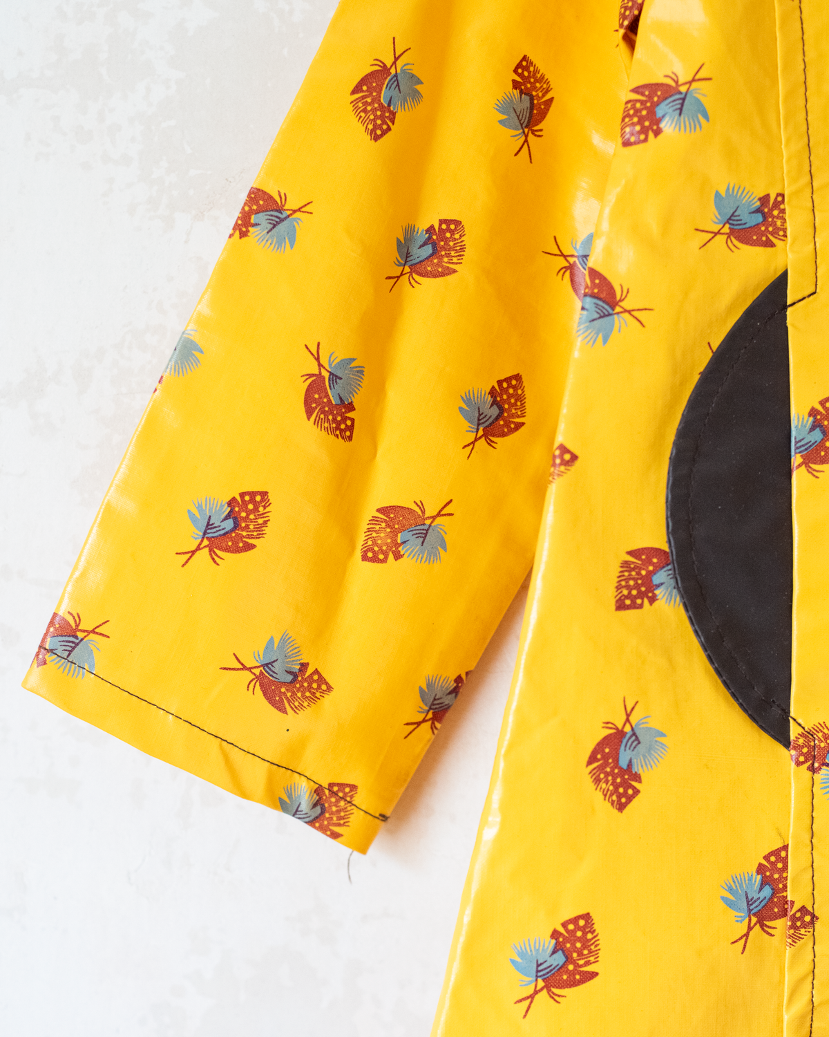 Yellow raincoat with hood and feather print | 7-8 years