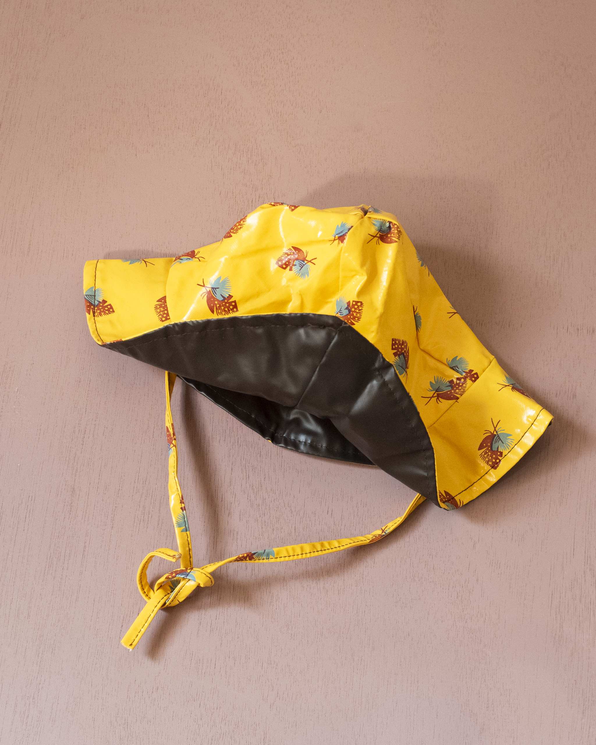 מעיל גשם צהוב עם כובע והדפס נוצות | 7-8 שנים