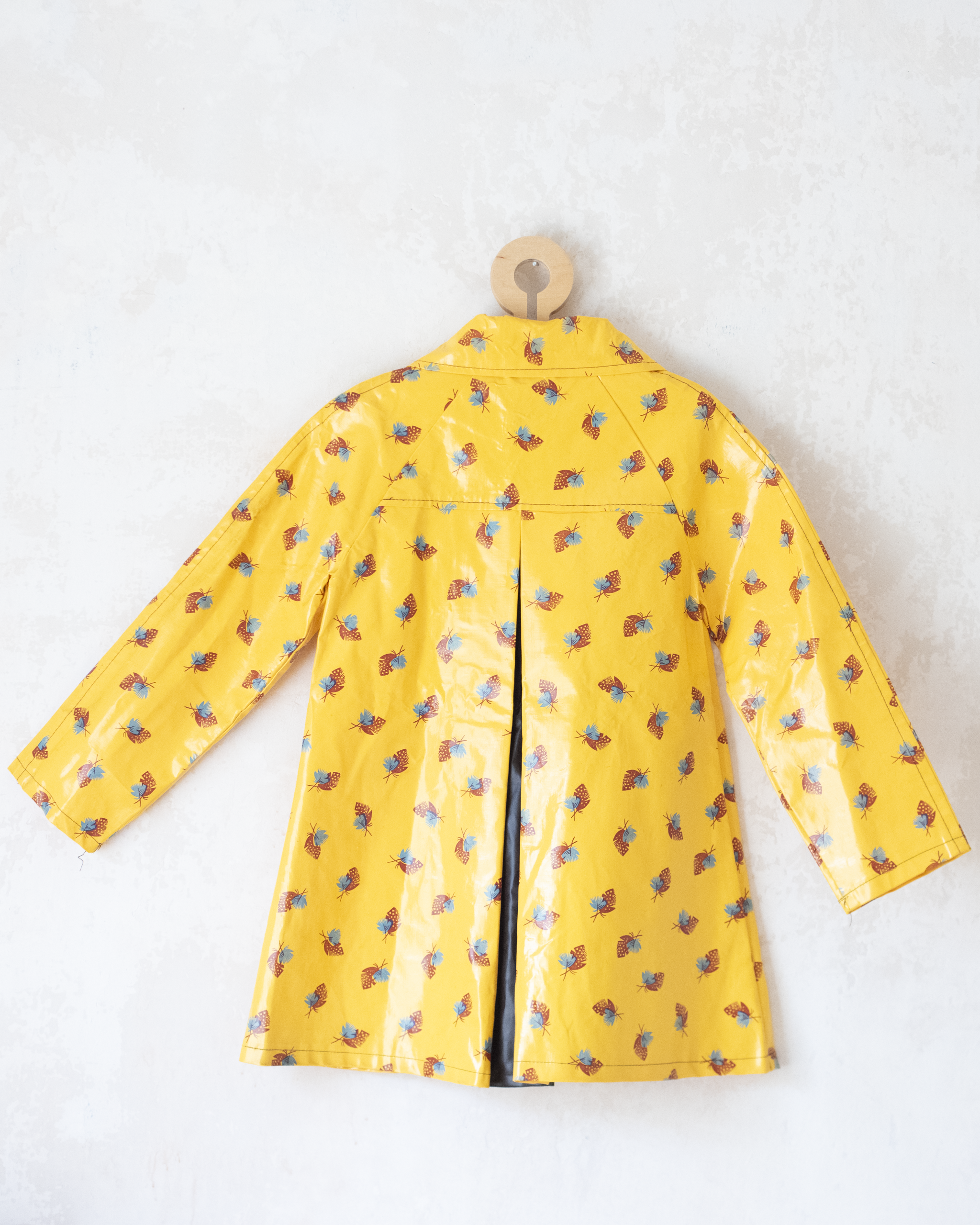 מעיל גשם צהוב עם כובע והדפס נוצות | 7-8 שנים