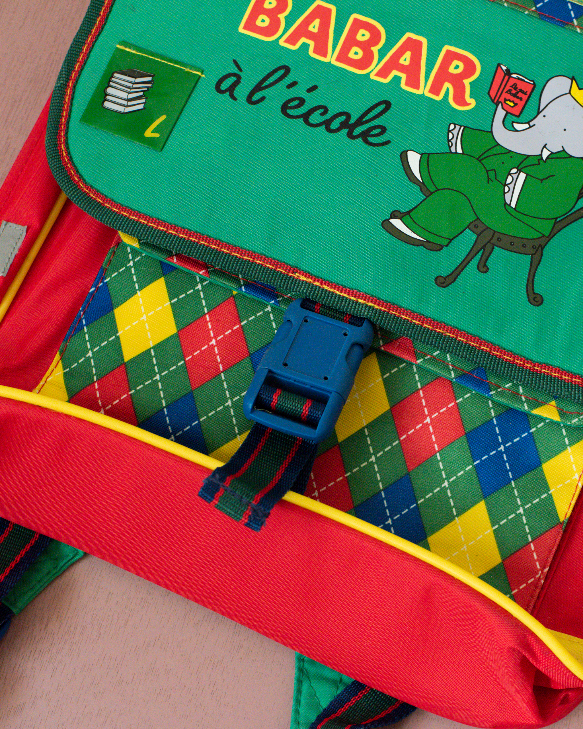 ילקוט ירוק עם מעוינים צבעוניים והמלך בבר