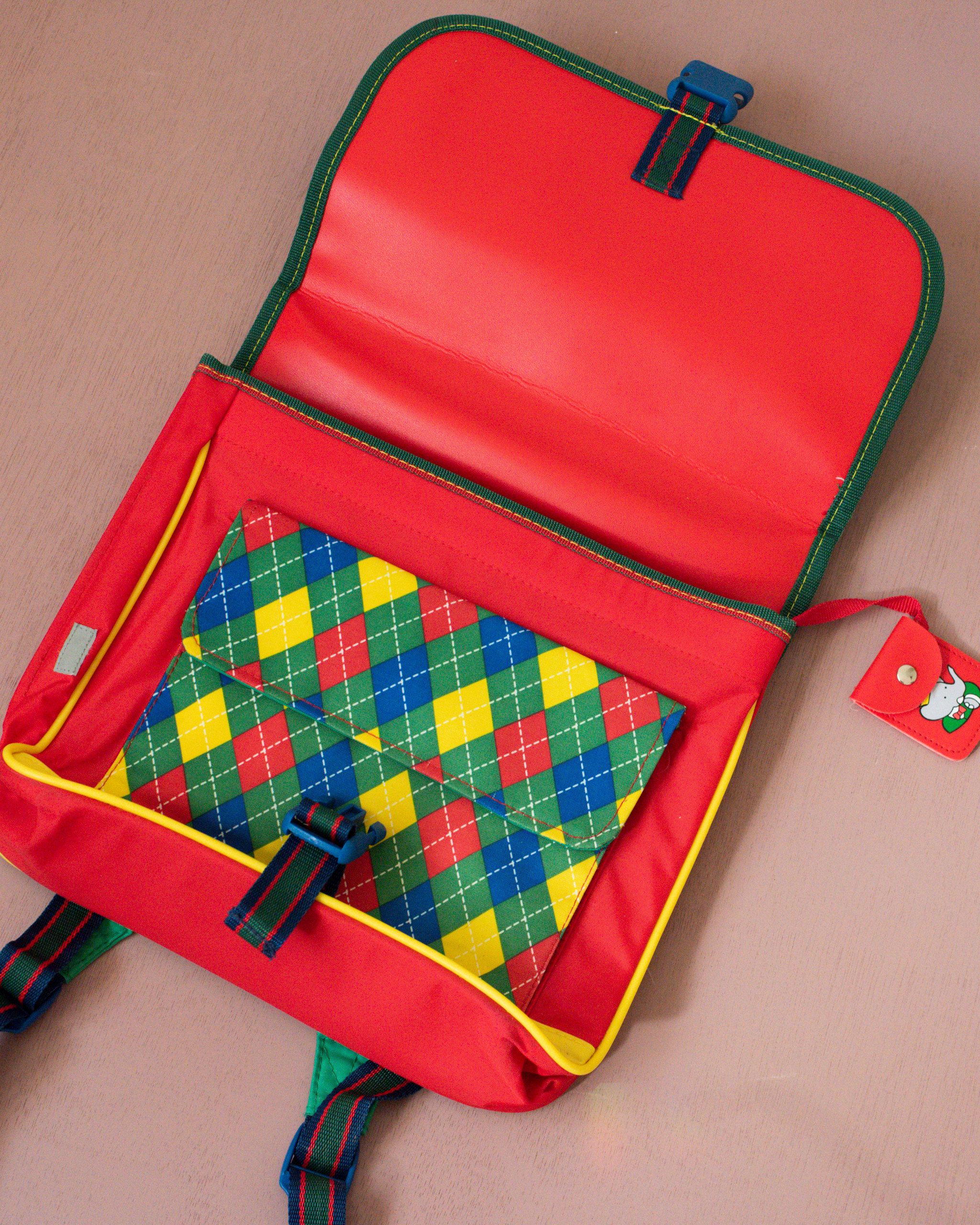 ילקוט ירוק עם מעוינים צבעוניים והמלך בבר