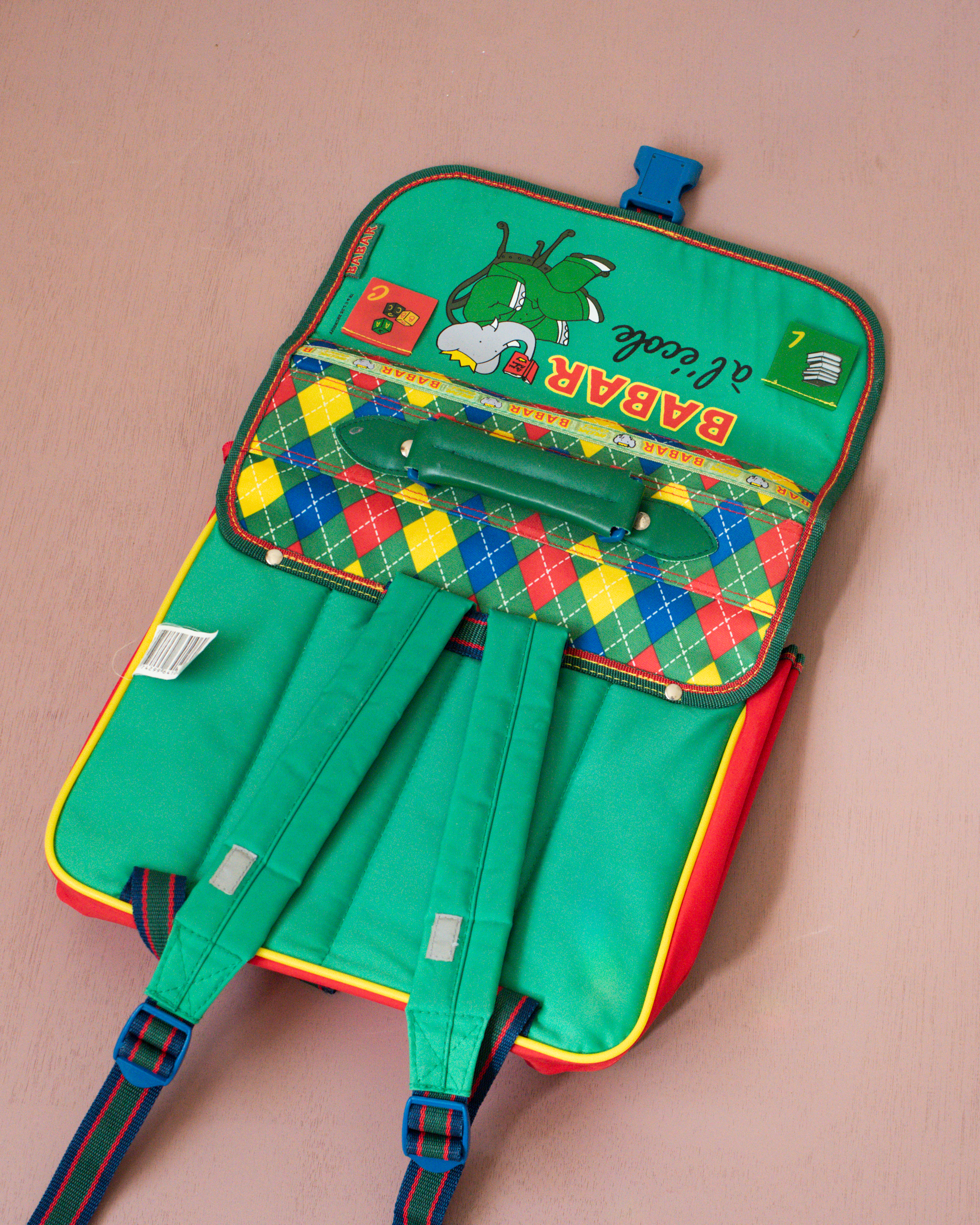 ילקוט ירוק עם מעוינים צבעוניים והמלך בבר