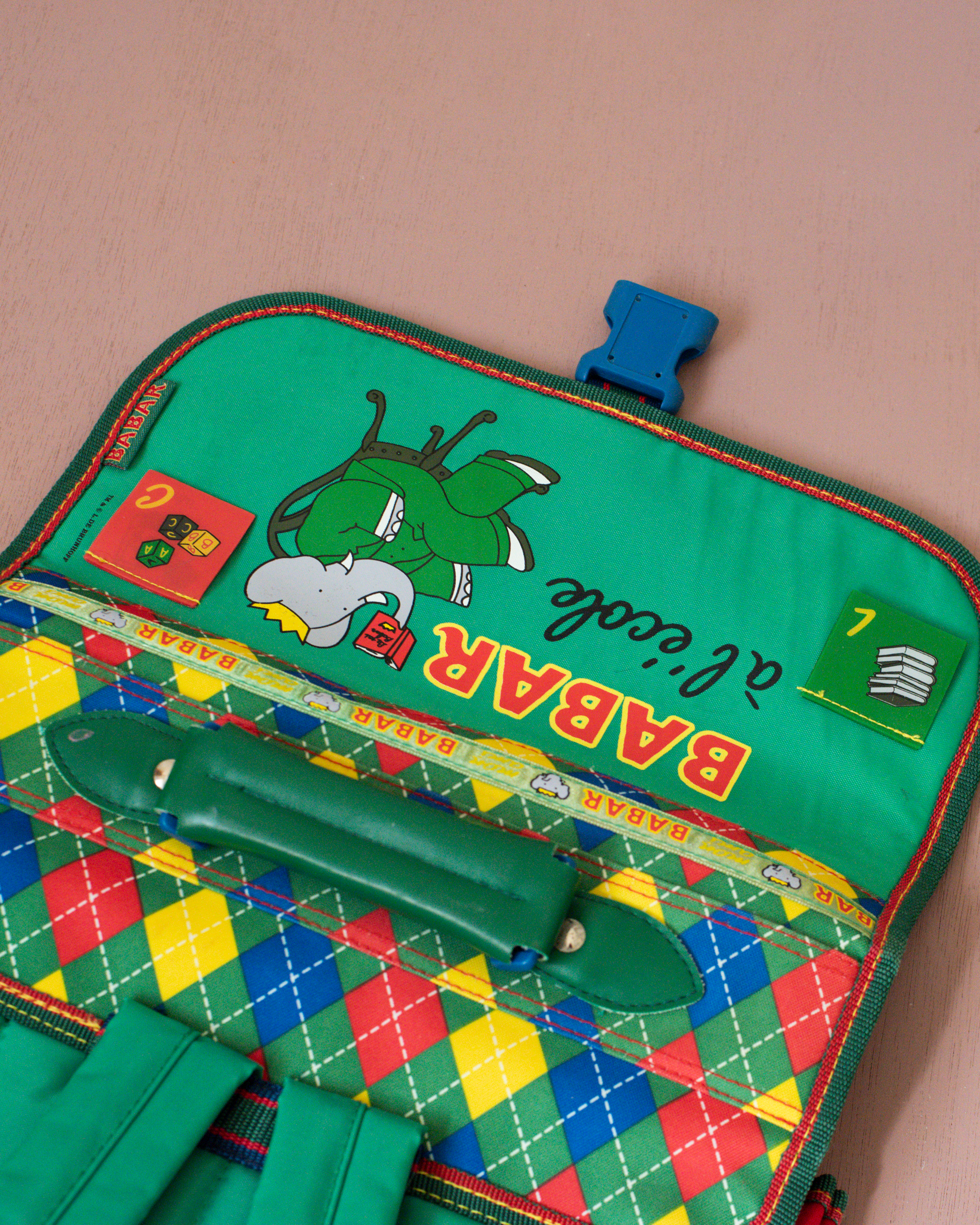 ילקוט ירוק עם מעוינים צבעוניים והמלך בבר