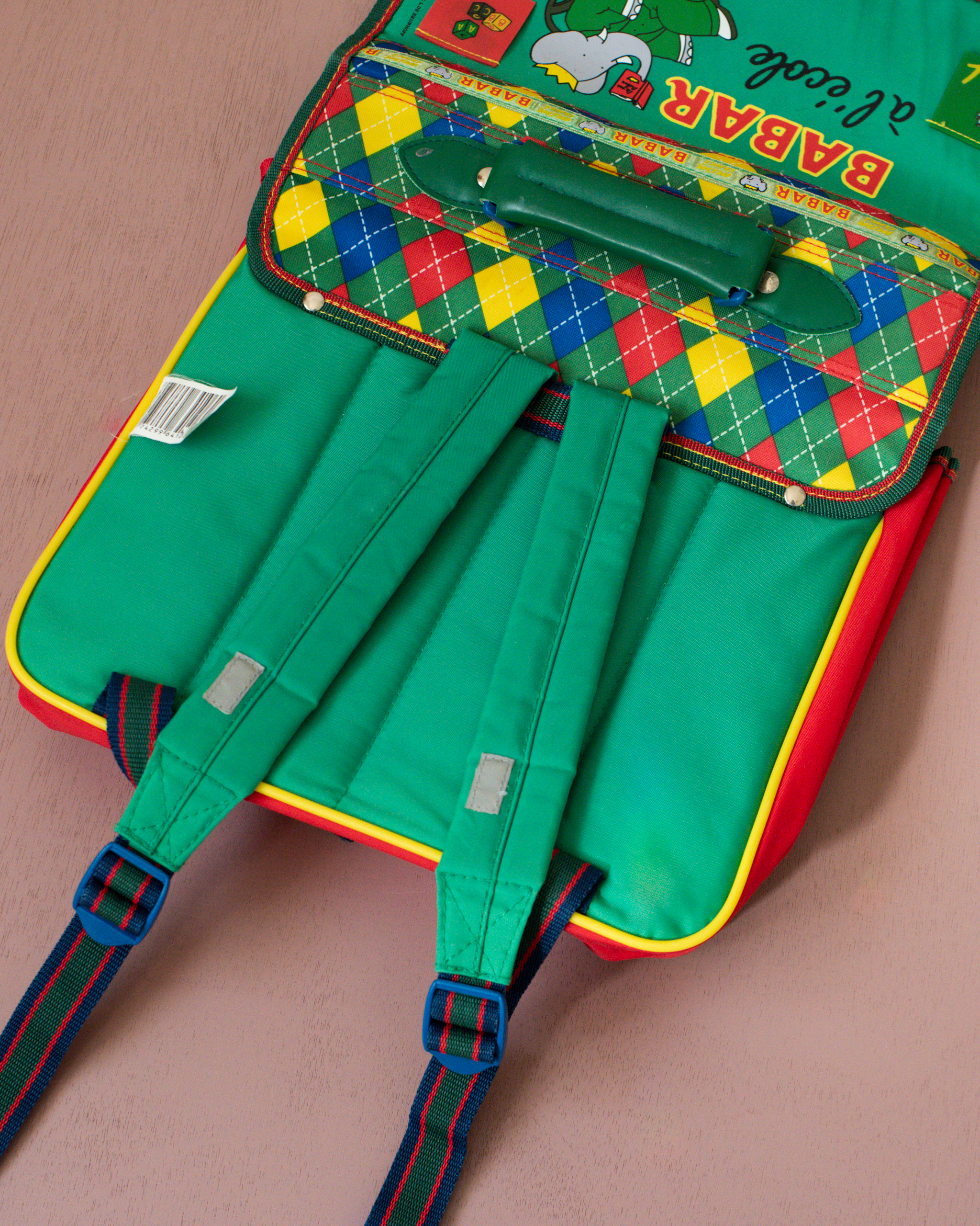 ילקוט ירוק עם מעוינים צבעוניים והמלך בבר