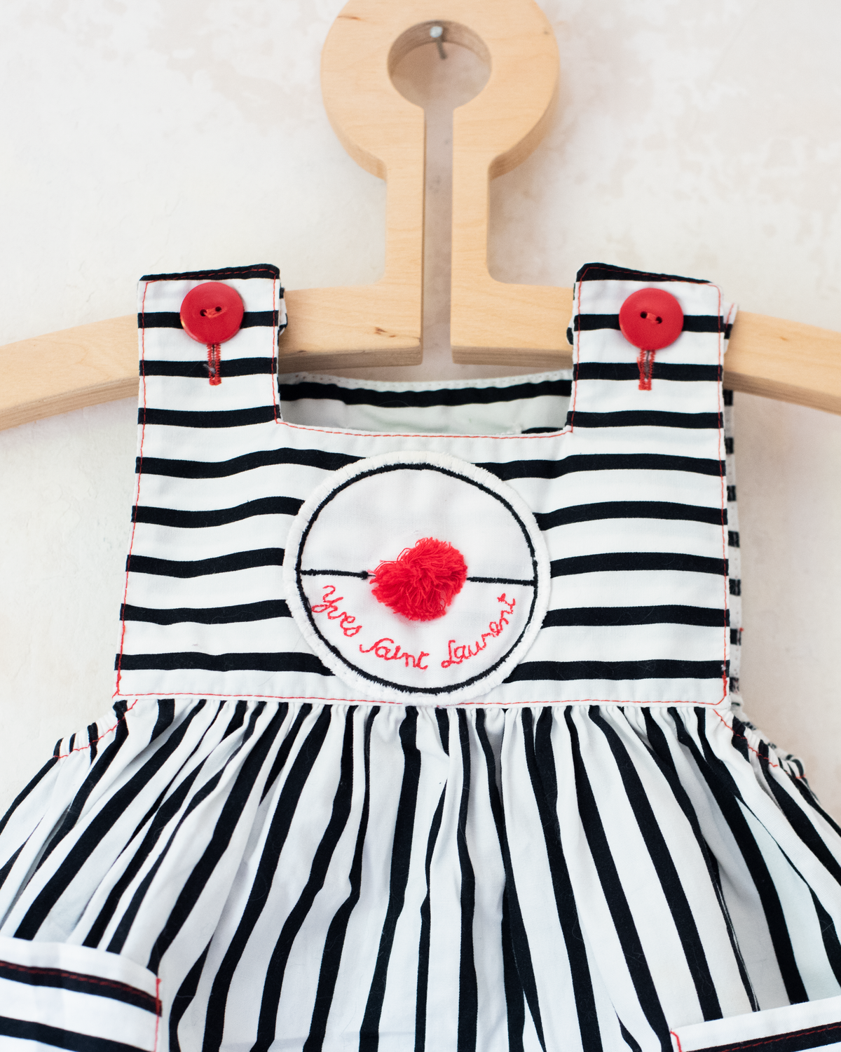 Striped overalls and pom-poms from Yves Saint Laurent | 3-6 months