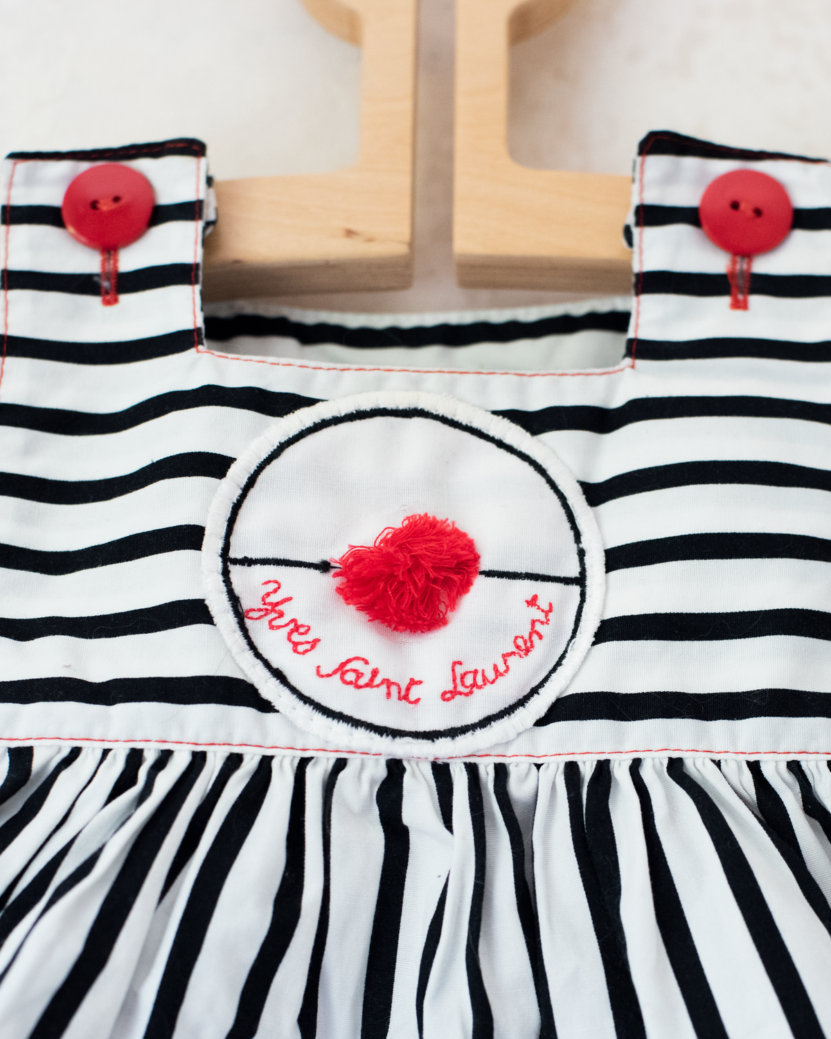 Striped overalls and pom-poms from Yves Saint Laurent | 3-6 months