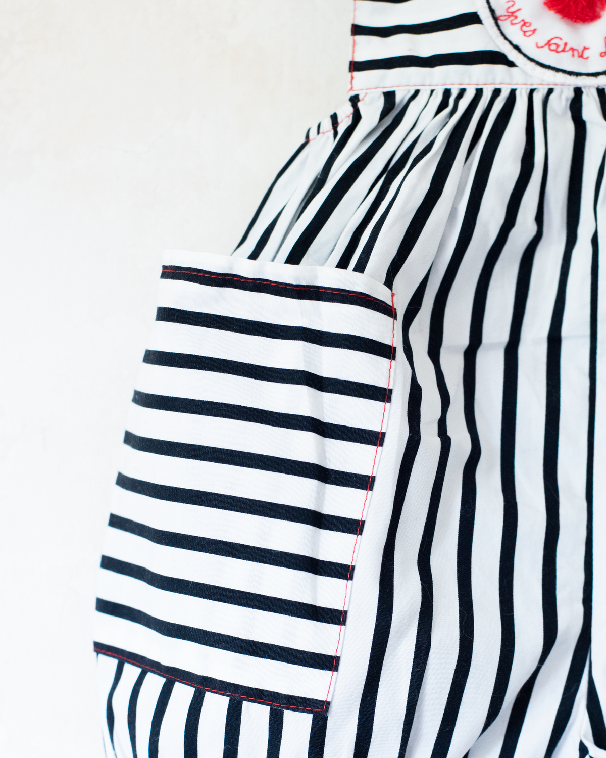 Striped overalls and pom-poms from Yves Saint Laurent | 3-6 months