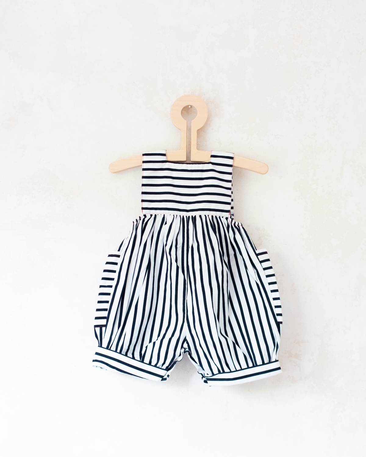 Striped overalls and pom-poms from Yves Saint Laurent | 3-6 months