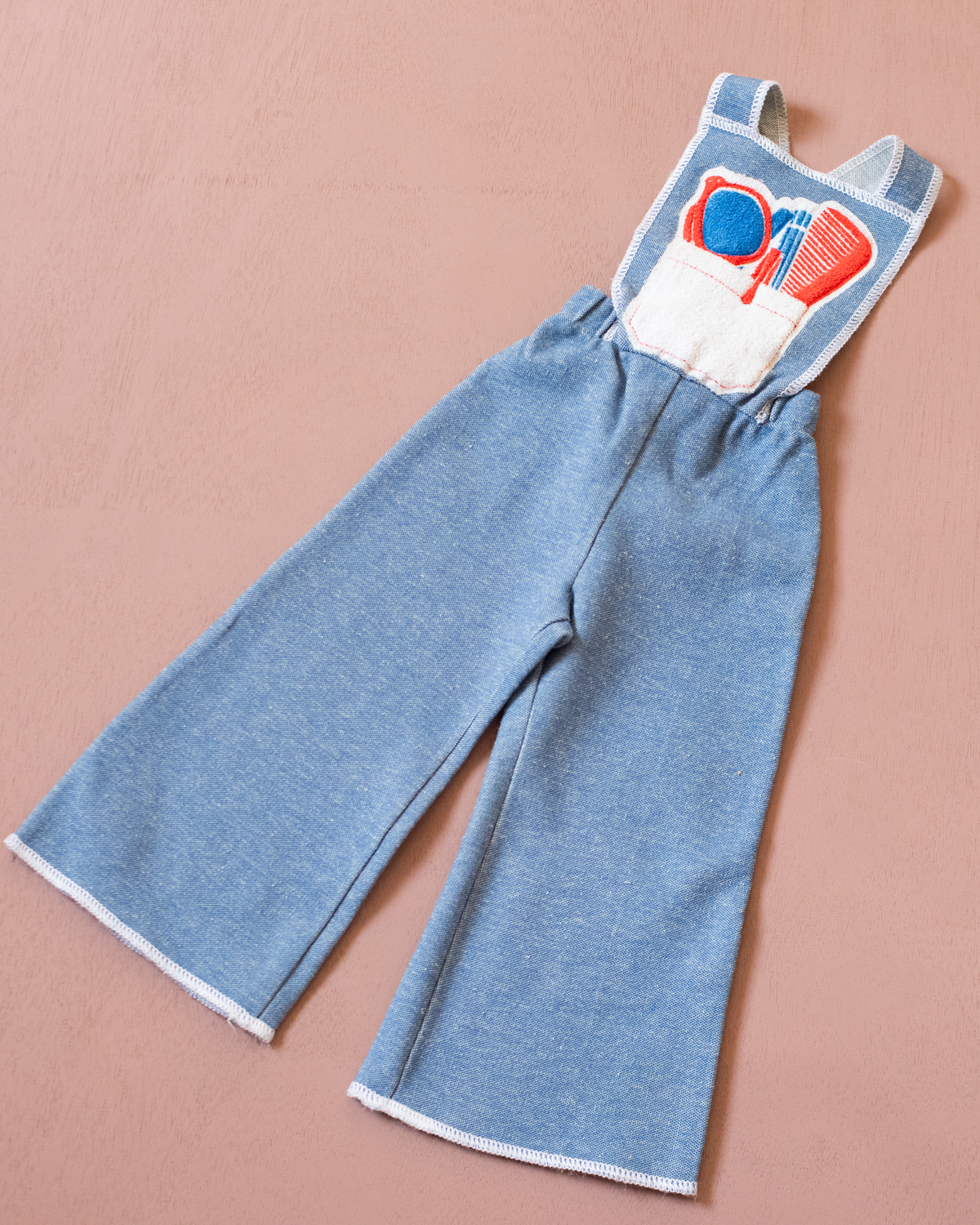 Light blue overalls from the 70s with accessories print on the front pocket | 9-12 months
