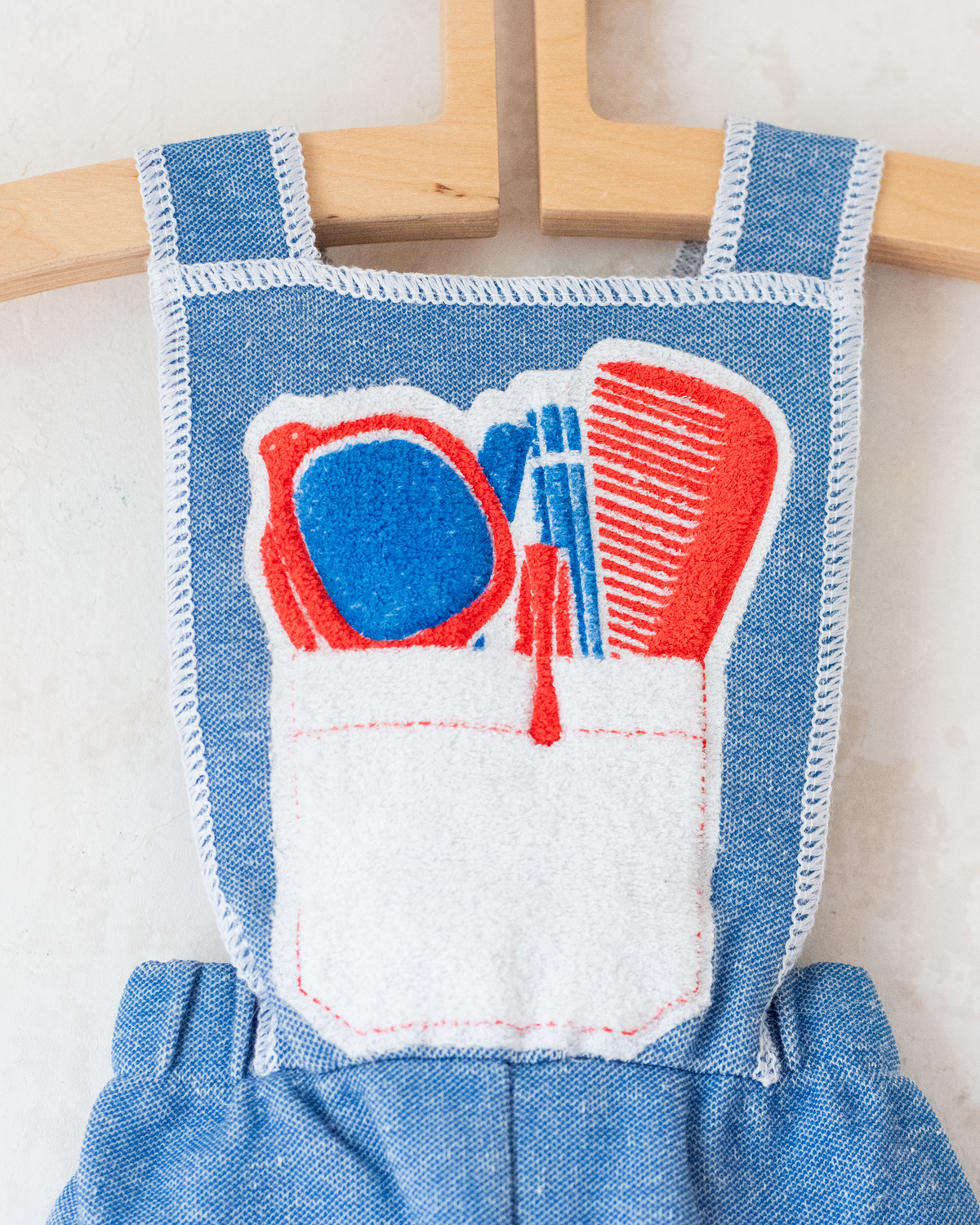Light blue overalls from the 70s with accessories print on the front pocket | 9-12 months