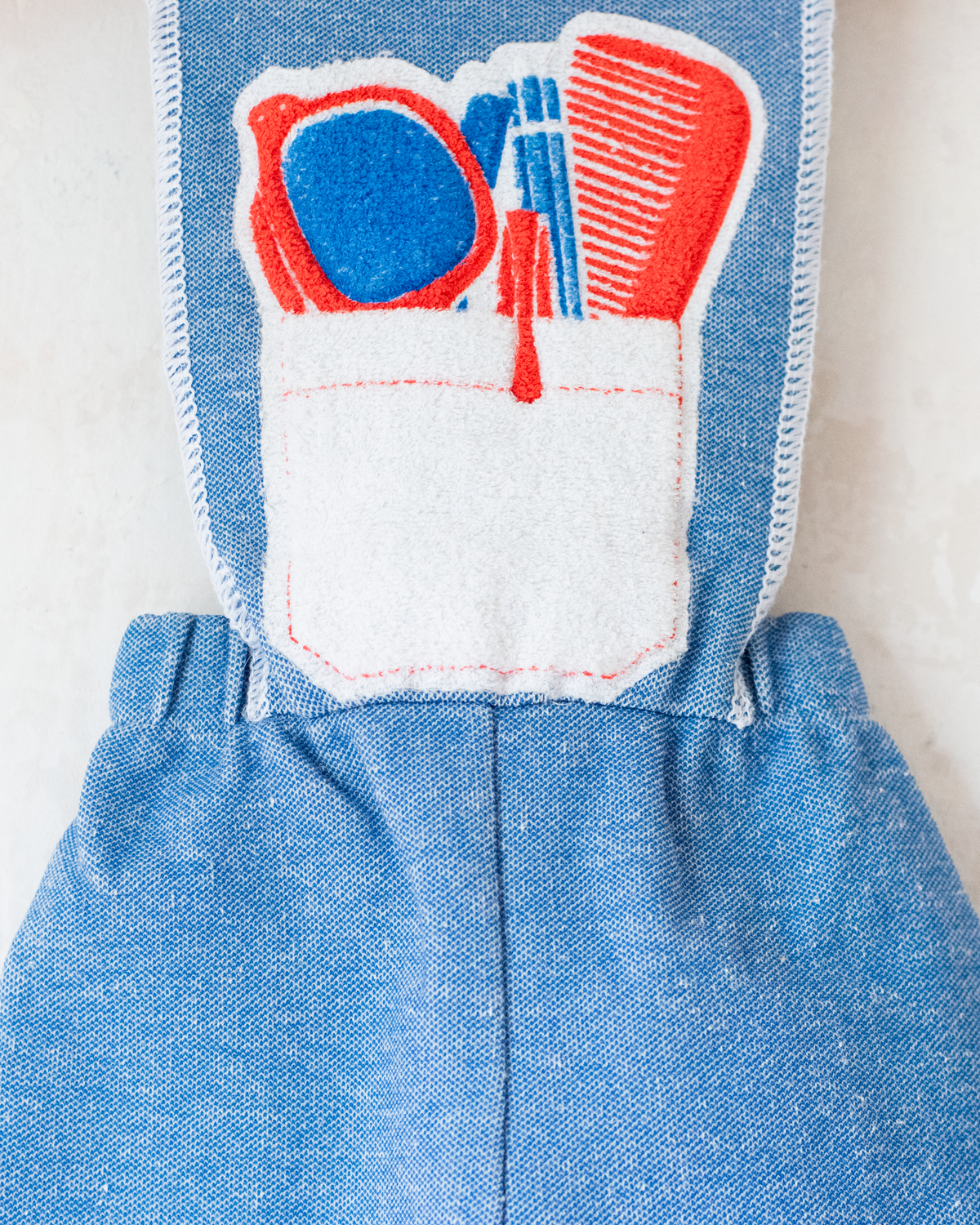 Light blue overalls from the 70s with accessories print on the front pocket | 9-12 months
