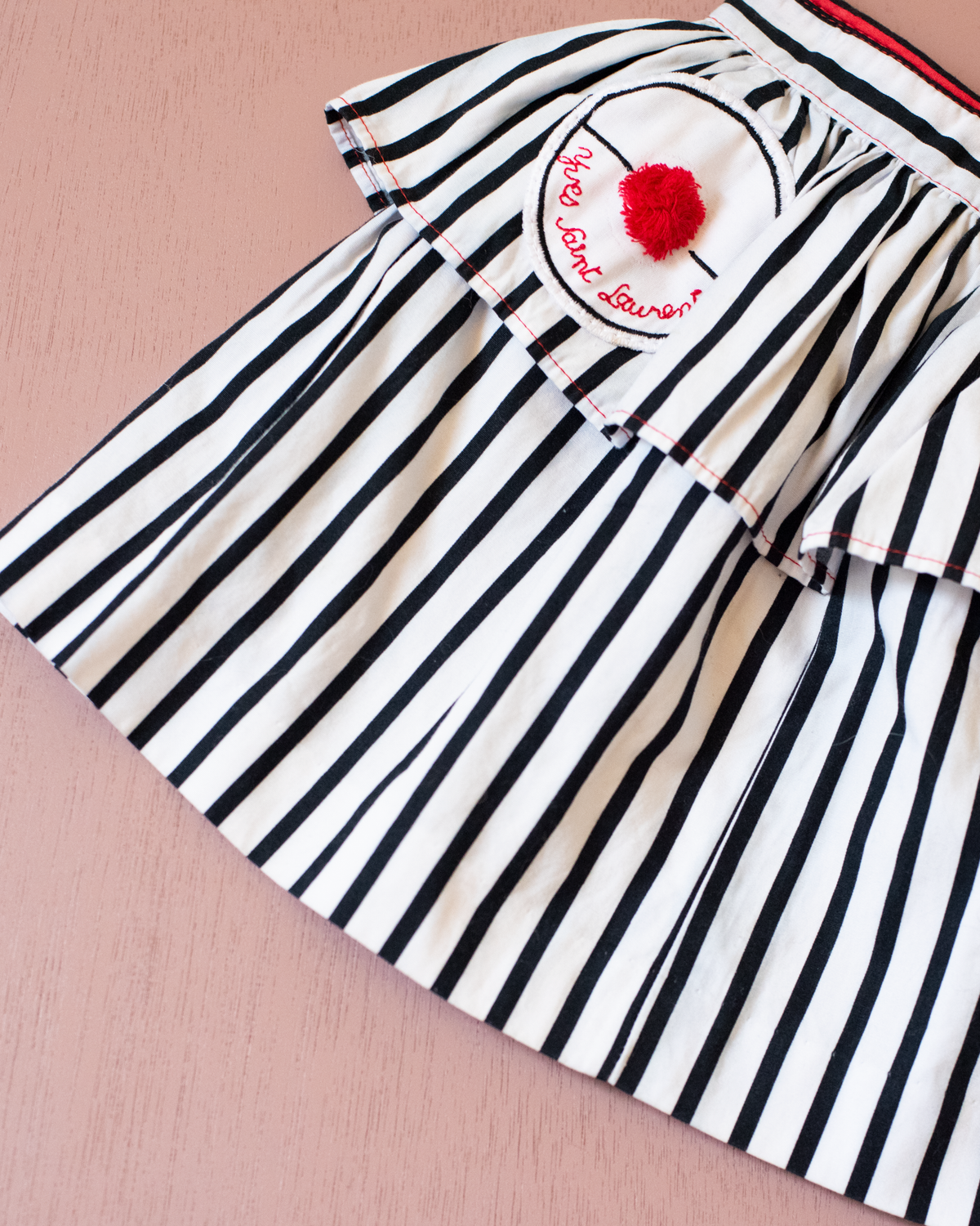 Striped skirt with a red pompom from Yves Saint Laurent | 3-4 years