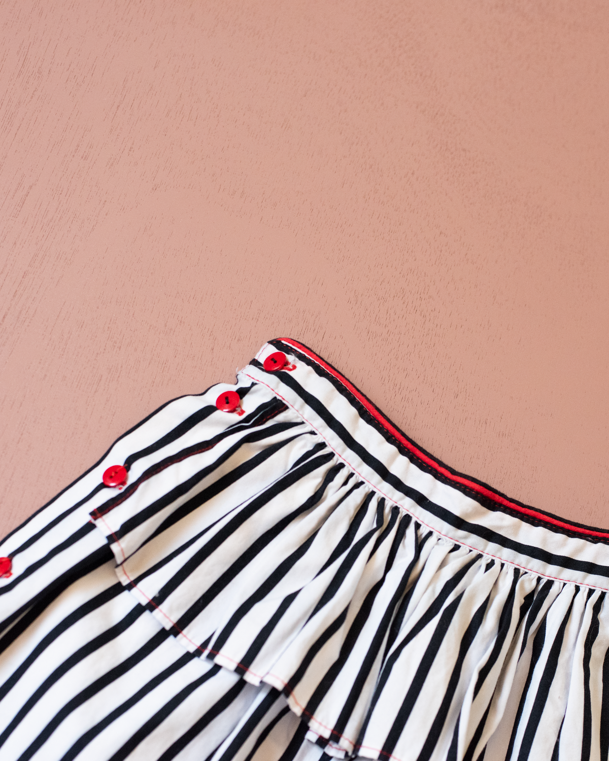 Striped skirt with a red pompom from Yves Saint Laurent | 3-4 years