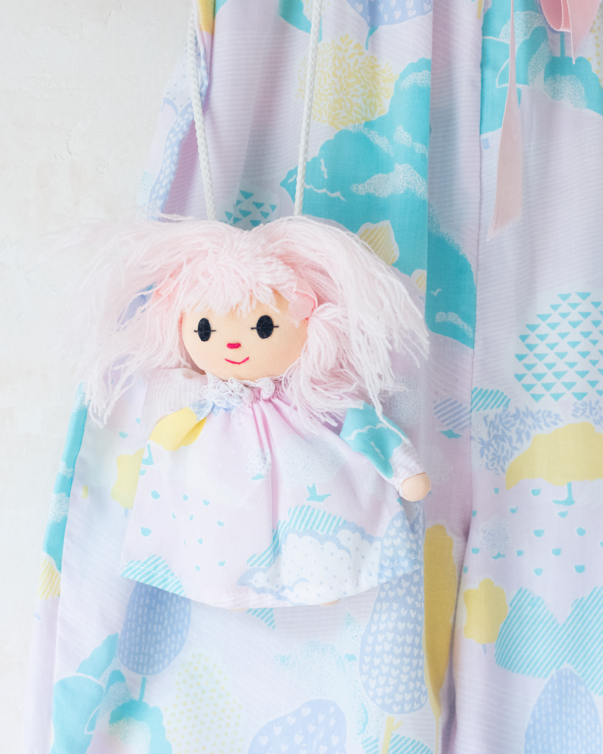 Pastel colored overalls with tree print and doll on a string | 18-24 months