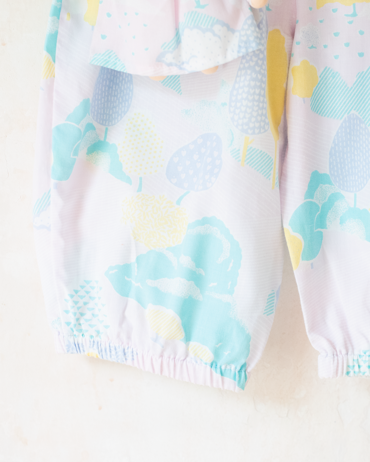 Pastel colored overalls with tree print and doll on a string | 18-24 months