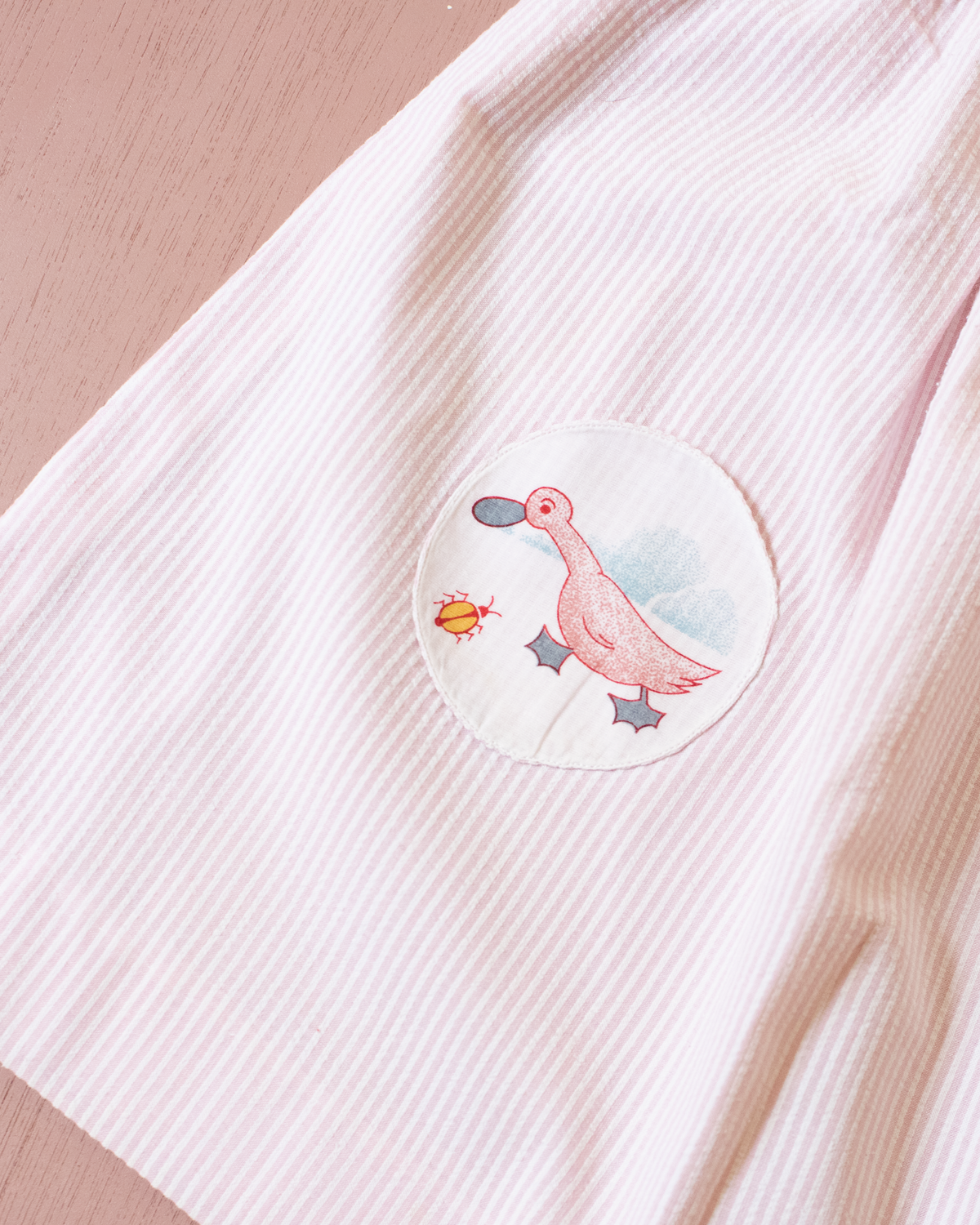 Pink and white striped dress with a goose pocket | 9-12 months